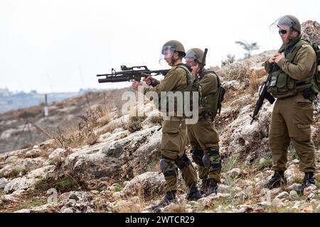 Bilin, Ramallah, Palestine. 31 décembre 2010. Des militaires des Forces de défense israéliennes se tiennent debout avec des lance-gaz et des fusils lors des manifestations hebdomadaires palestiniennes du vendredi contre l'occupation des territoires palestiniens par Israël à Bilin, Cisjordanie, Palestine, le 11 novembre 2010. Bilin, un petit village près de Ramallah, organise des manifestations hebdomadaires car une grande partie des terres des agriculteurs locaux a été annexée par les autorités israéliennes pour construire une nouvelle colonie juive. (Crédit image : © Dominika Zarzycka/SOPA images via ZUMA Press Wire) USAGE ÉDITORIAL SEULEMENT! Non destiné à UN USAGE commercial ! Banque D'Images