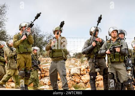 Bilin, Ramallah, Palestine. 31 décembre 2010. Des militaires des Forces de défense israéliennes se tiennent debout avec des lance-gaz et des fusils lors des manifestations hebdomadaires palestiniennes du vendredi contre l'occupation des territoires palestiniens par Israël à Bilin, Cisjordanie, Palestine, le 11 novembre 2010. Bilin, un petit village près de Ramallah, organise des manifestations hebdomadaires car une grande partie des terres des agriculteurs locaux a été annexée par les autorités israéliennes pour construire une nouvelle colonie juive. (Crédit image : © Dominika Zarzycka/SOPA images via ZUMA Press Wire) USAGE ÉDITORIAL SEULEMENT! Non destiné à UN USAGE commercial ! Banque D'Images