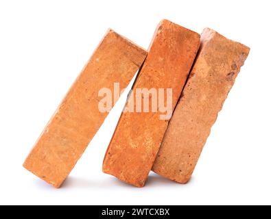 Vue latérale de vieilles briques rouges ou oranges fissurées dans la pile est isolée sur fond blanc avec chemin de détourage. Banque D'Images