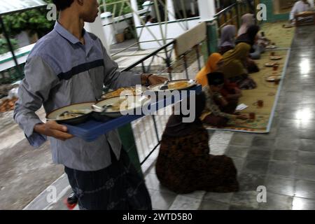 17 mars 2024, Bantul, Yogyakarta, Indonésie : un musulman indonésien a distribué de la bouillie de légumes comme repas pour rompre le jeûne pendant le mois Saint du Ramadan connu sous le nom de ''Takjil'' à la mosquée Sabilurrosyad ou à la mosquée Kauman. La mosquée maintient toujours la tradition de takjil sous la forme de bouillie de légumes. La nourriture avec une texture lisse et douce est faite par les gens qui travaillent ensemble. Un jour ordinaire, l'administrateur de la mosquée peut servir 100 portions de bouillie de légumes. Mais le vendredi, le porridge de légumes servi peut atteindre 400 portions. (Crédit image : © Angga Budhiyanto/ZUMA Press W Banque D'Images