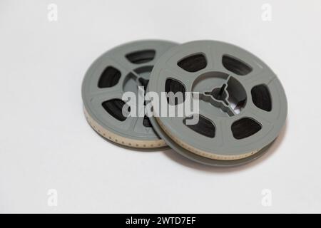 Deux bobines de vieux film de 8 mm empilées l'une sur l'autre sur un fond blanc. Banque D'Images