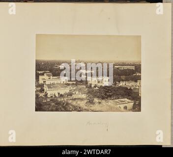 Pondichéry. Inconnu, photographe des années 1870 vue surélevée d'une partie de la ville de Pondichéry ou Puducherry, montrant un certain nombre de bâtiments de deux étages avec des toits plats. Un toit plat, envahi par des arbustes et d'autres végétaux, peut être vu sur la partie inférieure de l'image. La cathédrale notre-Dame de l’Immaculée conception, également connue sous le nom de « Cathédrale de notre-Dame de l’Immaculée conception » ou « Samba Kovil », est visible au loin avec son dôme et sa façade baroque. (Recto, monture) en bas au centre, au crayon : 'Pondichéry' ; (verso, monture) en bas à gauche, au crayon : « A48.86 »; Banque D'Images