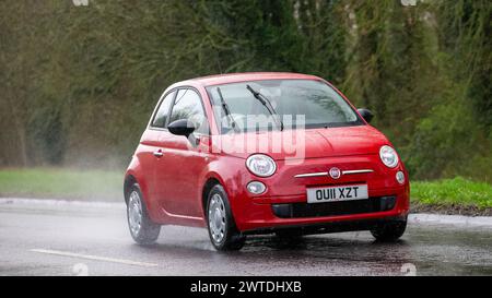 Milton Keynes, UK-Mar 17th 2024 : 2011 rouge Fiat 500 voiture conduisant sous la pluie Banque D'Images