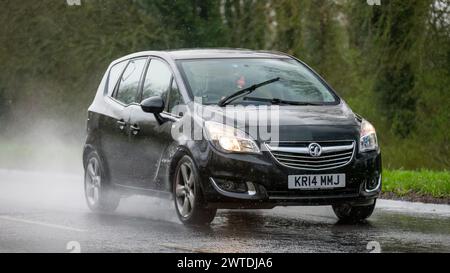 Milton Keynes, UK-Mar 17th 2024 : 2014 voiture noire Vauxhall Meriva conduisant sous la pluie Banque D'Images