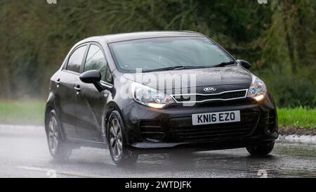 Milton Keynes, UK-Mar 17th 2024 : 2016 voiture noire Kia Rio conduisant sous la pluie Banque D'Images