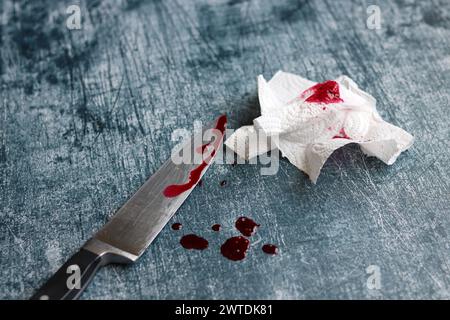 Gros couteau sanglant sur fond gris grungy avec espace de copie. Gouttes de sang sur fond rouillé. Concept de violence domestique. Banque D'Images