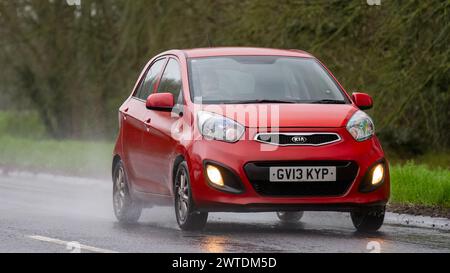 Milton Keynes, UK-Mar 17th 2024 : 2013 voiture rouge Kia Picanto conduisant sous la pluie Banque D'Images