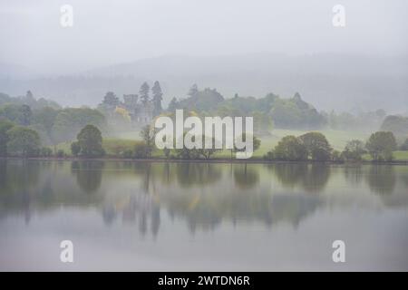 Regardant à travers le lac Windermere vers le château de Wray par un matin de printemps brumeux. Banque D'Images