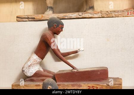 Musée égyptien du Caire, statuette modèle d'un serviteur pétrissant de la pâte pour faire du pain. Banque D'Images