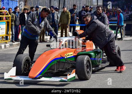 Srinagar, Inde. 17 mars 2024. Les officiels poussent une voiture de course lors d’un événement de sport automobile organisé pour dynamiser le tourisme dans la vallée, à Srinagar. Pour promouvoir le tourisme dans la vallée du Cachemire, la course automobile de formule 4 de 1,7 km de long a eu lieu sur les rives du célèbre lac Dal. La course comportait des cascades de pilotes professionnels de formule 4. Crédit : SOPA images Limited/Alamy Live News Banque D'Images