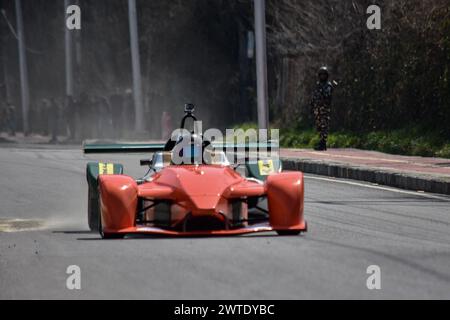 Srinagar, Inde. 17 mars 2024. Une voiture de course se déplace le long de la route lors d’un événement de sport automobile organisé pour dynamiser le tourisme dans la vallée, à Srinagar. Pour promouvoir le tourisme dans la vallée du Cachemire, la course automobile de formule 4 de 1,7 km de long a eu lieu sur les rives du célèbre lac Dal. La course comportait des cascades de pilotes professionnels de formule 4. Crédit : SOPA images Limited/Alamy Live News Banque D'Images