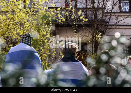 Cracovie, Pologne, 17 mars 2024. Les manifestants arborent des drapeaux de l'opposition russe devant le consulat russe à Cracovie le troisième jour de l'élection présidentielle russe à midi. Le leader de l'opposition russe, récemment décédé en prison, Alexei Navalny, puis son épouse Julia Navalna, ont appelé l'opposition à venir aux urnes le 17 mars à midi, pour montrer au président russe Vladimir Poutine le nombre de personnes qui s'opposent à son règne. Il est illégal et dangereux de protester contre le gouvernement en Russie, c'est pourquoi Navalny a suggéré l'idée de se rassembler aux urnes à un certain moment. CR Banque D'Images