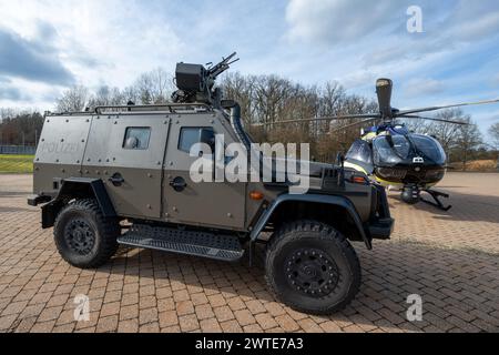 Sulzbach Rosenberg, Allemagne. 17 mars 2024. Le véhicule offensif blindé Enok 6,2 des forces spéciales se tient à côté du nouvel hélicoptère Airbus H145 D3 sur le terrain de la police anti-émeute lors du grand exercice international. Des unités spéciales de police et de douane ainsi que des membres des forces armées allemandes, des services de secours, des pompiers et des organisations de secours techniques participent à l'exercice de lutte contre le terrorisme 'exercice de lutte contre le terrorisme 2024'. Crédit : Armin Weigel/dpa/Alamy Live News Banque D'Images