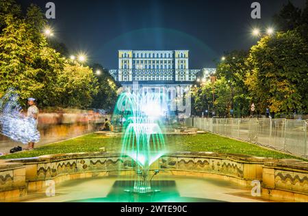 Fontaines d'eau dansantes à Union Square (Piata Unirii) parc dans le centre de Bucarest, Roumanie et le Palais du Parlement également connu sous le nom de peuple s. Banque D'Images