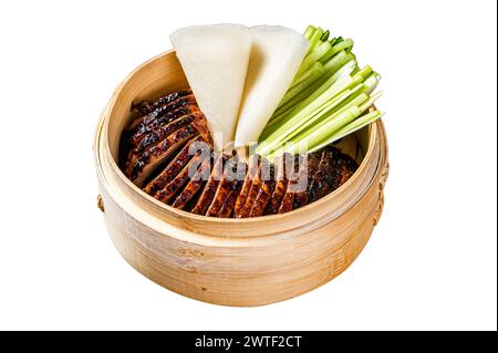 Canard laqué dans un cuiseur vapeur en bambou servi avec concombre, oignon vert et crêpes chinoises au blé. Isolé sur fond blanc. Vue de dessus. Banque D'Images