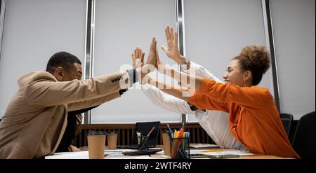 Groupe de divers hommes d'affaires utilisant un ordinateur portable tout en travaillant ensemble dans un espace de travail moderne. Banque D'Images