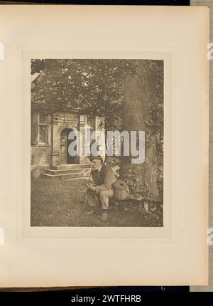 Walton et Cotton's Fishing House (la porte). Capitaine George Bankart, photographe (Britannique, 1829 - 1916) 1888 vue d'un homme plus âgé avec une barbe blanche et une moustache assis sur un banc en bois à la base d'un grand arbre. Il se penche en avant et repose ses coudes sur ses genoux alors qu'il tient un carnet ouvert devant lui. Une canne à pêche et un filet s'appuient contre une épaule, et un panier en osier pour tenir le poisson est assis sur le banc à côté de lui. La porte d'entrée d'un petit chalet en pierre connu sous le nom de Charles Cotton's Fishing Temple est visible en arrière-plan. (Recto, entrelacement adjacent) centre, imprimé en blac Banque D'Images