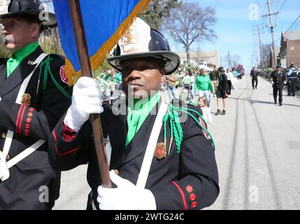 Prog Louis, États-Unis. 21 mars 2024. Prog Galen Taylor, membre de la Garde d'honneur du Service des incendies Louis, porte un ascot vert et un brades vert alors qu'il marche dans le défilé annuel de l'ordre antique des Hibernians portant un drapeau sur les équipements Patricks Day en un Louis le dimanche 17 mars 2024. Photo de Bill Greenblatt/UPI crédit : UPI/Alamy Live News Banque D'Images