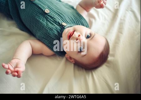 Mignon petit garçon nouveau-né drôle reposant paisiblement sur des draps beiges dans le lit ou la crèche. Modèle d'emballage pour produits pour bébés. Enfant sain, concept d'hôpital et maternité heureuse. Bébé nourrisson. Crèche. Banque D'Images