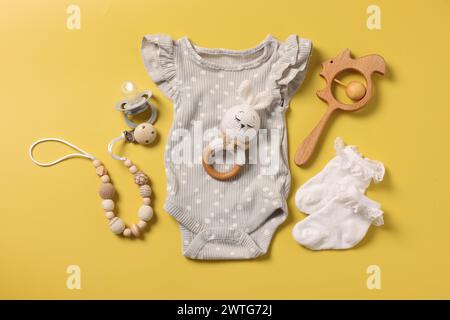 Différents accessoires de bébé sur fond jaune, plat Banque D'Images