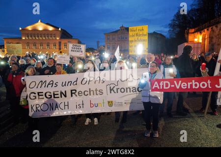 Coburg, Allemagne. 17 mars 2024. Les manifestants tiennent une banderole et des pancartes pendant la manifestation. Une manifestation anti-AFD a eu lieu à Coburg avec des orateurs de plusieurs partis et groupes qui se sont adressés à une foule nombreuse à Schlossplatz. L’événement s’est conclu par une chaîne de lumières créée par des personnes utilisant les torches de leurs téléphones portables. Parmi les intervenants présents à l’événement figuraient des représentants du Parti vert, des syndicats et des organisations locales ainsi que des immigrants qui vivent en Allemagne depuis plusieurs années. Crédit : SOPA images Limited/Alamy Live News Banque D'Images