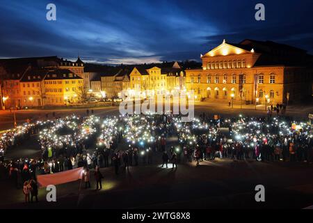 Coburg, Allemagne. 17 mars 2024. Les manifestants utilisent des téléphones portables pendant la manifestation. Une manifestation anti-AFD a eu lieu à Coburg avec des orateurs de plusieurs partis et groupes qui se sont adressés à une foule nombreuse à Schlossplatz. L’événement s’est conclu par une chaîne de lumières créée par des personnes utilisant les torches de leurs téléphones portables. Parmi les intervenants présents à l’événement figuraient des représentants du Parti vert, des syndicats et des organisations locales ainsi que des immigrants qui vivent en Allemagne depuis plusieurs années. Crédit : SOPA images Limited/Alamy Live News Banque D'Images