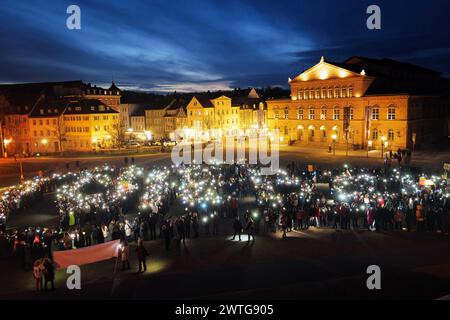 Coburg, Allemagne. 17 mars 2024. Les manifestants utilisent des téléphones portables pendant la manifestation. Une manifestation anti-AFD a eu lieu à Coburg avec des orateurs de plusieurs partis et groupes qui se sont adressés à une foule nombreuse à Schlossplatz. L’événement s’est conclu par une chaîne de lumières créée par des personnes utilisant les torches de leurs téléphones portables. Parmi les intervenants présents à l’événement figuraient des représentants du Parti vert, des syndicats et des organisations locales ainsi que des immigrants qui vivent en Allemagne depuis plusieurs années. (Photo Liam Cleary/SOPA images/SIPA USA) crédit : SIPA USA/Alamy Live News Banque D'Images