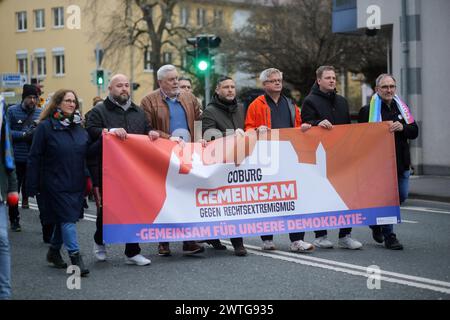 Coburg, Allemagne. 17 mars 2024. Les manifestants tiennent une banderole pendant la manifestation. Une manifestation anti-AFD a eu lieu à Coburg avec des orateurs de plusieurs partis et groupes qui se sont adressés à une foule nombreuse à Schlossplatz. L’événement s’est conclu par une chaîne de lumières créée par des personnes utilisant les torches de leurs téléphones portables. Parmi les intervenants présents à l’événement figuraient des représentants du Parti vert, des syndicats et des organisations locales ainsi que des immigrants qui vivent en Allemagne depuis plusieurs années. (Photo Liam Cleary/SOPA images/SIPA USA) crédit : SIPA USA/Alamy Live News Banque D'Images