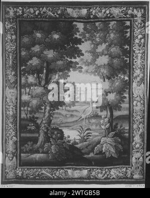 Paysage avec gibier-oiseau. Unknown c. 1675-1700 dimensions de tapisserie : H 9'5' x l 7'6' matériaux/techniques de tapisserie : inconnu culture : Centre de tissage français : Aubusson historique de propriété : French & Co. acheté de Wanamaker, reçu le 2/8/1916 ; vendu à J. Wanamaker le 1/28/1920. Faisan (?) Au premier plan parmi les plantes à fleurs et les arbres, tourné vers oiseau dans l'arbre (l) ; rivière au centre menant à un grand bâtiment avec des arches en arrière-plan ; bâtiment supplémentaire caché derrière les arbres (l) (BRD) bordure incorporant panier de fleurs, fruits et fleurs avec trophées noués ruban, masques grotesques et autres décors Banque D'Images