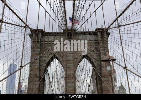 Pont de Brooklyn, gros plan d'une tour de pont avec un drapeau agitant, enveloppé dans des cordes et des câbles, Manhattan, New York City, New York, États-Unis, Amérique du Nord Banque D'Images