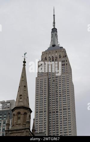 Vue de l'Empire State Building à côté d'une flèche d'église, toile de fond architecturale urbaine, Manhattan, New York City, New York, États-Unis, Amérique du Nord Banque D'Images