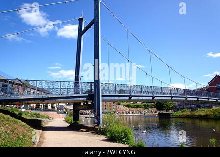 Vue du pont suspendu Cricklepit sur la rivière Exe avec des restaurants à l'arrière vu de la rive ouest, Exeter, Devon, Royaume-Uni, Europe. Banque D'Images