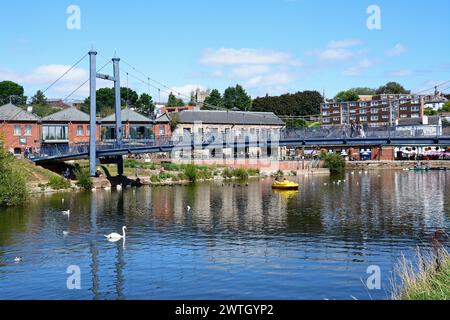 Vue du pont suspendu de Cricklepit au-dessus de la rivière Exe avec des cygnes au premier plan et un pédalo sous le pont, Exeter, Devon, Royaume-Uni, Europe. Banque D'Images