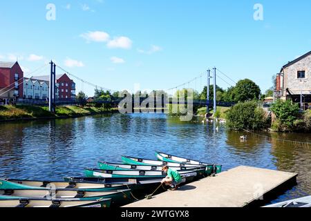 Vue de la rivière Exe avec le pont suspendu Cricklepit à l'arrière et bateaux à rames amarrés au premier plan, Exeter, Devon, Royaume-Uni, Europe. Banque D'Images