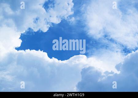 Nuages blancs moelleux formant un cadre sur un ciel bleu vibrant Banque D'Images