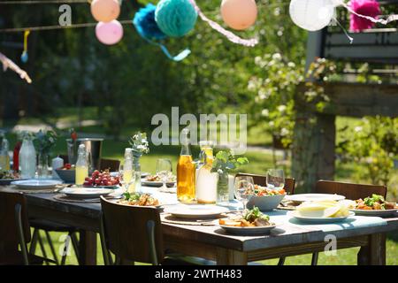 Gros plan de la table de préparation à la fête d'été, grillades. Table avec verres, limonade, délicate décoration florale et papier, et Banque D'Images