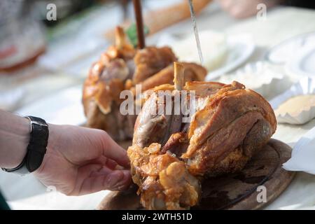 AUTRICHE ; VIENNE ; 20240315 ; serveur sert l'original Schweizerhaus Stelze (pilotis de la maison suisse) aux invités à une table dans le jardin de bière du célèbre restaurant Schweizerhaus dans le parc d'attractions Prater de Vienne pendant l'ouverture de la saison à Vienne le 15 mars 2024. Le restaurant Schweizerhaus est connu pour ses bières Schweinsstelzen et Budweiser. - 20240315 PD16994 crédit : APA-PictureDesk/Alamy Live News Banque D'Images