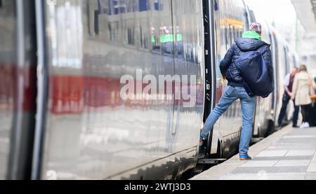 Hanovre, Allemagne. 18 mars 2024. Un homme se tient près d'un train ICE à la gare centrale de Hanovre. Les deux parties au conflit salarial à Deutsche Bahn ont repris les négociations. Le Groupe et le syndicat des conducteurs de train GDL sont confiants de parvenir à un accord cette semaine, selon un communiqué de Deutsche Bahn. Crédit : Julian Stratenschulte/dpa/Alamy Live News Banque D'Images