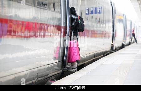 Hanovre, Allemagne. 18 mars 2024. Une femme monte à bord d'un train DE GLACE avec une valise à la gare centrale de Hanovre. Les deux parties au conflit salarial à Deutsche Bahn ont repris les négociations. L'entreprise et le syndicat des conducteurs de train GDL sont confiants de parvenir à un accord cette semaine, selon un communiqué de Deutsche Bahn. Crédit : Julian Stratenschulte/dpa/Alamy Live News Banque D'Images