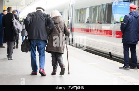 Hanovre, Allemagne. 18 mars 2024. Un couple âgé marche bras dans bras à côté d'un train ICE à la gare centrale de Hanovre. Les deux parties au conflit salarial à Deutsche Bahn ont repris les négociations. Le Groupe et le syndicat des conducteurs de train GDL sont confiants de parvenir à un accord cette semaine, selon un communiqué de Deutsche Bahn. Crédit : Julian Stratenschulte/dpa/Alamy Live News Banque D'Images