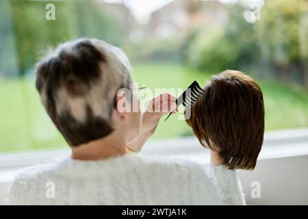 Femme avec alopécie peignant une perruque Banque D'Images