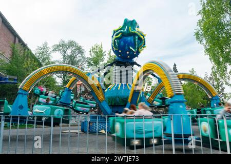 Helsinki, Finlande - 21 mai 2023 : carrousel Mustekala en mouvement dans le parc d'attractions Linnanmaki Banque D'Images