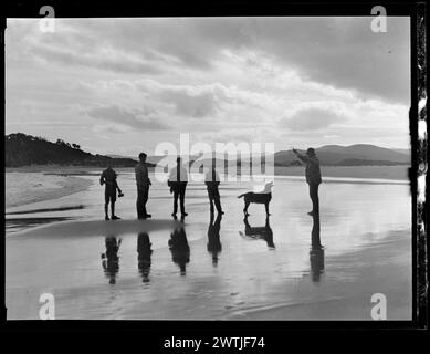 Les gens et un chien sur la plage gélatine argentée négatifs, négatifs noir et blanc Banque D'Images