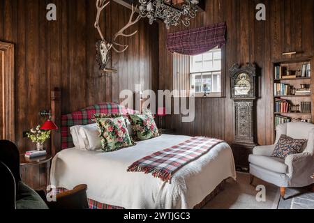 Bois fixés au mur au-dessus du lit avec couverture en tartan dans un hôtel de luxe à Ardfin sur l'île du Jura, Hébrides intérieures, Écosse, Royaume-Uni Banque D'Images