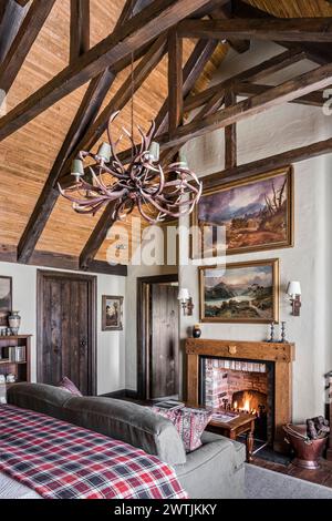 Lumière de bois au-dessus du canapé au coin du feu dans un hôtel de luxe à Ardfin sur l'île du Jura, Hébrides intérieures, Écosse, Royaume-Uni Banque D'Images