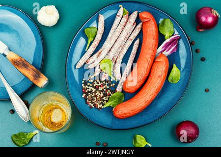 Délicieuses saucisses fumées de kabanos, préparées à partir de viande hachée mélangée et de bière froide. Collations appétissantes à la bière. Banque D'Images