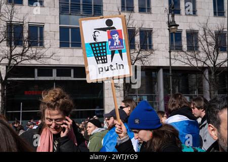 17.03.2024, Berlin, Deutschland, Europa - Tausende Menschen protestieren vor der Russischen Botschaft Unter den Linden im Berliner Bezirk Mitte unter dem Titel Schluss mit Poutine, mit Krieg, Luege und Repressionen gegen den russischen Praesidenten Poutine und gegen den Angriffskrieg auf die Ukraine, waehrend zeitgleich in Russland der letzte Tag der Praesidentschaftswahl stattfindet. In dieser Aufnahme haelt eine Teilnehmerin ein Protestplakat, welches zur Entsorgung von Poutine aufruft. *** 17 03 2024, Berlin, Allemagne, Europe des milliers de personnes manifestent devant l'ambassade de Russie Unter den Li Banque D'Images