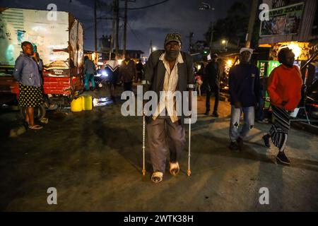 Les résidents rentrent chez eux tard dans la soirée en passant par les rues animées du bidonville de Kibera, Nairobi. Kibera, le plus grand bidonville de Nairobi et d'Afrique, abrite Banque D'Images