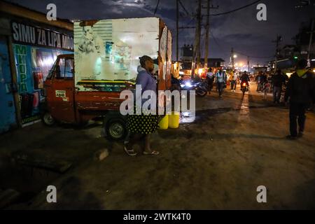 Les résidents rentrent chez eux tard dans la soirée en passant par les rues animées du bidonville de Kibera, Nairobi. Kibera, le plus grand bidonville de Nairobi et d'Afrique, abrite Banque D'Images