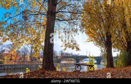 Un banc sur la rive dans un parc d'automne. Prague, République tchèque Banque D'Images